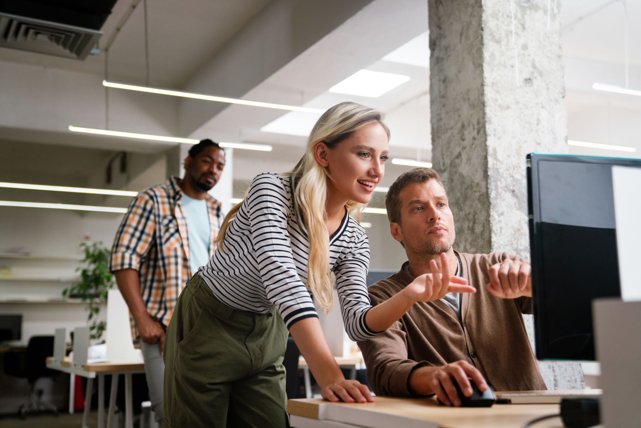 Group of young multi-ethnic startup business team collaborating on project in modern office. Young successful start-up entrepreneurs working as a team together.